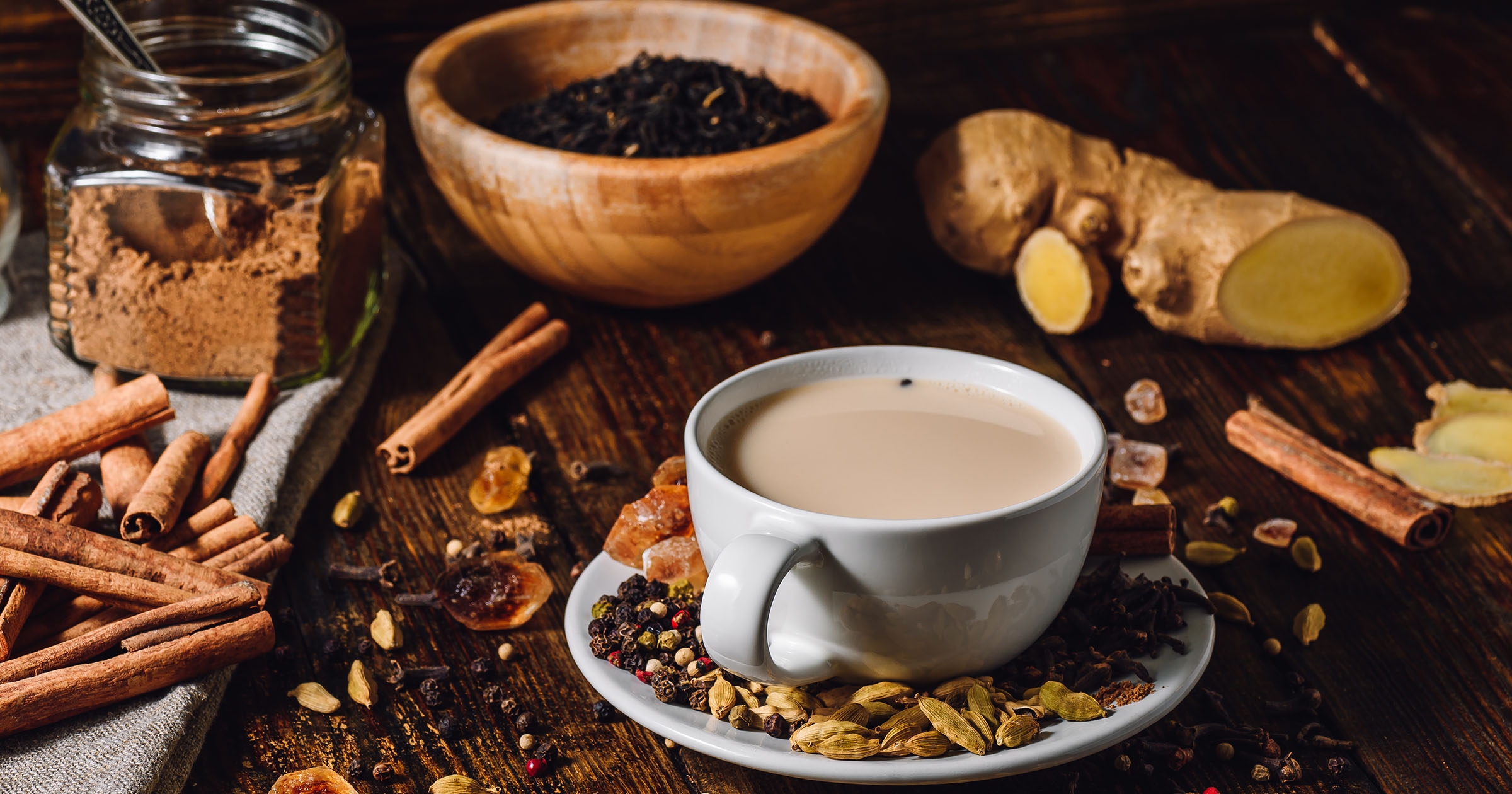 Herbal Tea Benefits: Herbal tea with spices and herbs, including cinnamon, on a wooden table.